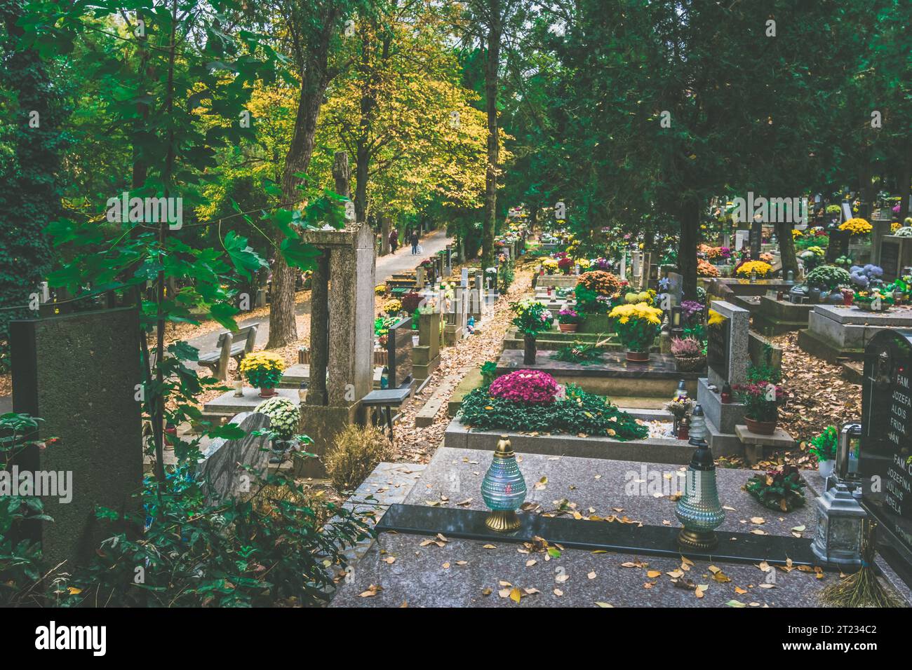 Celebrazione del giorno di tutte le anime nel cimitero, decorazione tradizionale cristiana su lapide, candele, lanterne, fiori Foto Stock