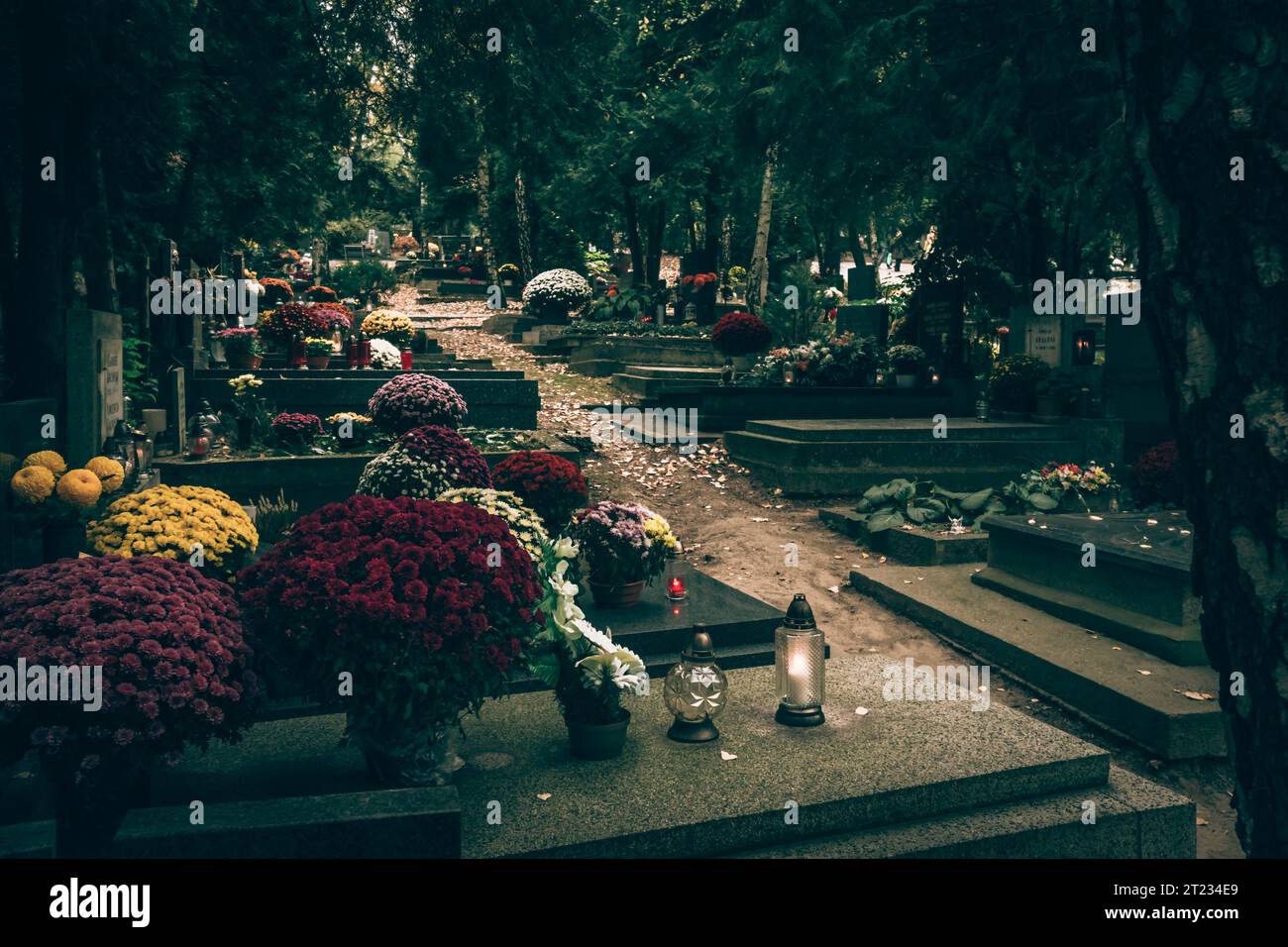 Celebrazione del giorno di tutte le anime nel cimitero, decorazione tradizionale cristiana su lapide, candele, lanterne, fiori Foto Stock