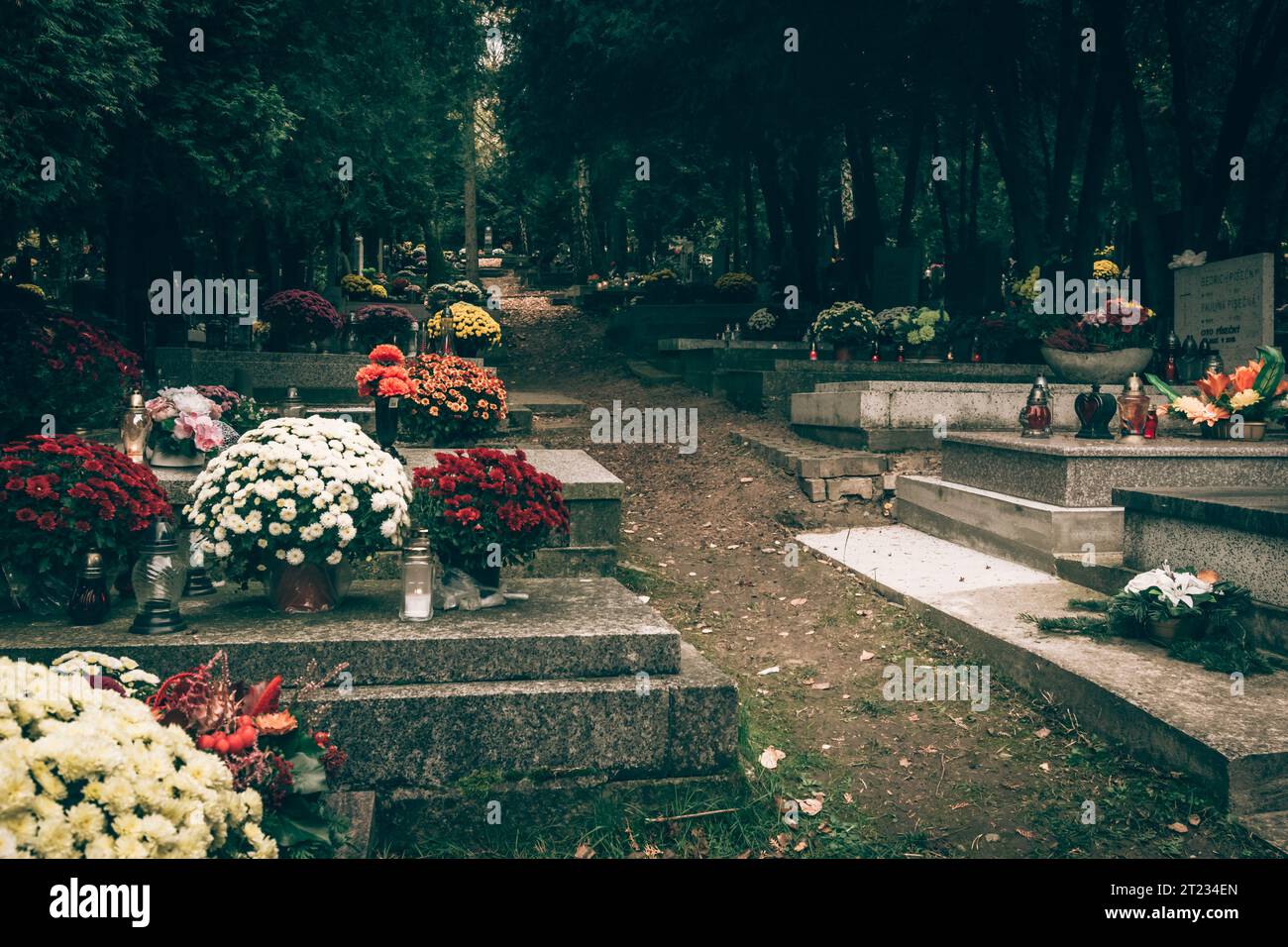 Celebrazione del giorno di tutte le anime nel cimitero, decorazione tradizionale cristiana su lapide, candele, lanterne, fiori Foto Stock