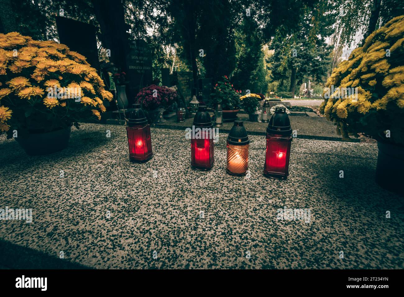 Celebrazione del giorno di tutte le anime nel cimitero, decorazione tradizionale cristiana su lapide, candele, lanterne, fiori Foto Stock
