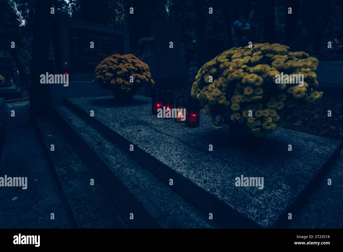 Celebrazione del giorno di tutte le anime nel cimitero, decorazione tradizionale cristiana su lapide, candele, lanterne, fiori Foto Stock