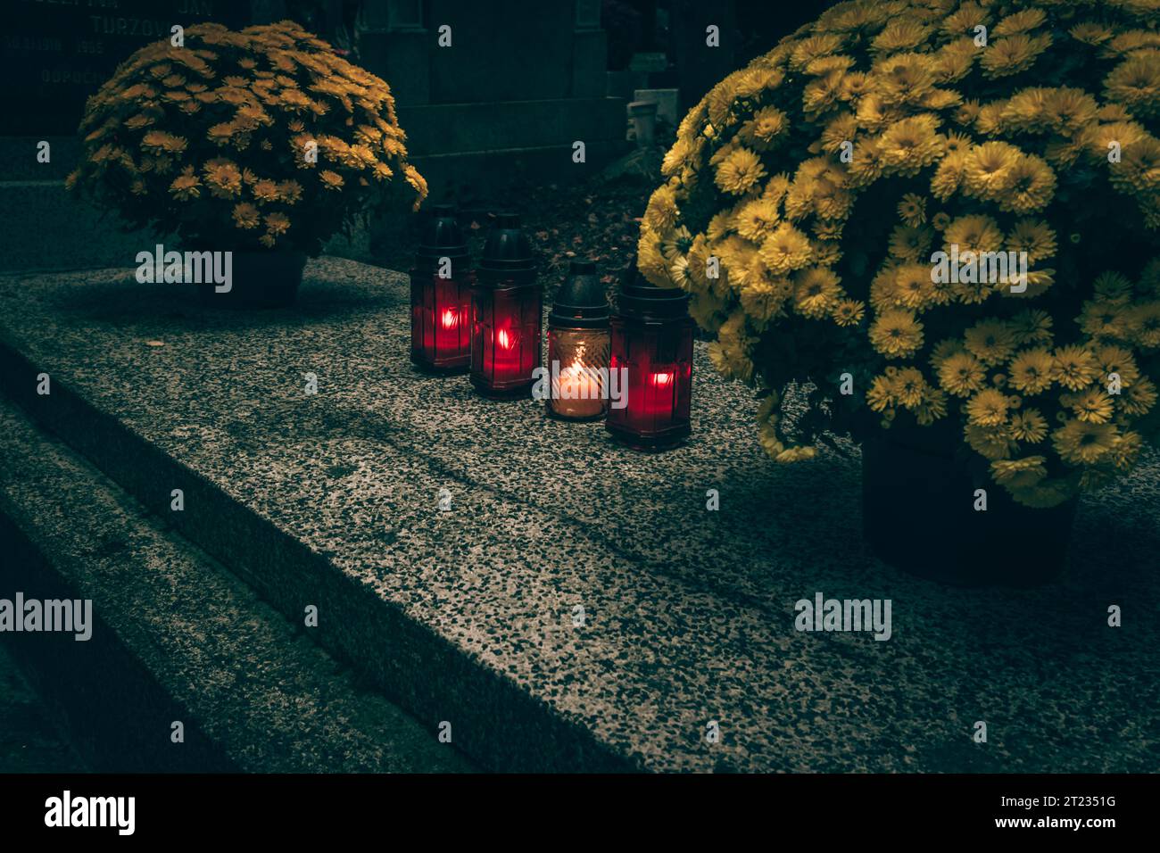 Celebrazione del giorno di tutte le anime nel cimitero, decorazione tradizionale cristiana su lapide, candele, lanterne, fiori Foto Stock