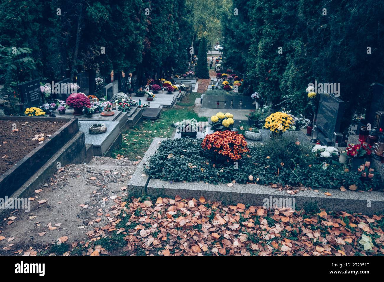 Celebrazione del giorno di tutte le anime nel cimitero, decorazione tradizionale cristiana su lapide, candele, lanterne, fiori Foto Stock