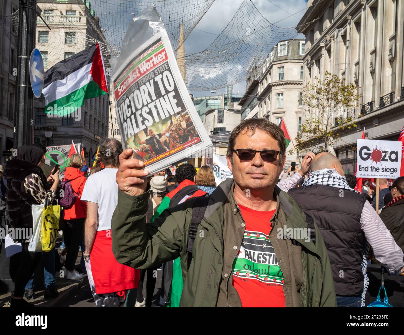 Londra, Regno Unito. 14 ottobre 2023: Un membro del Partito socialista dei lavoratori tiene una copia del giornale socialista dei lavoratori in una manifestazione pro-palestinese in cent Foto Stock