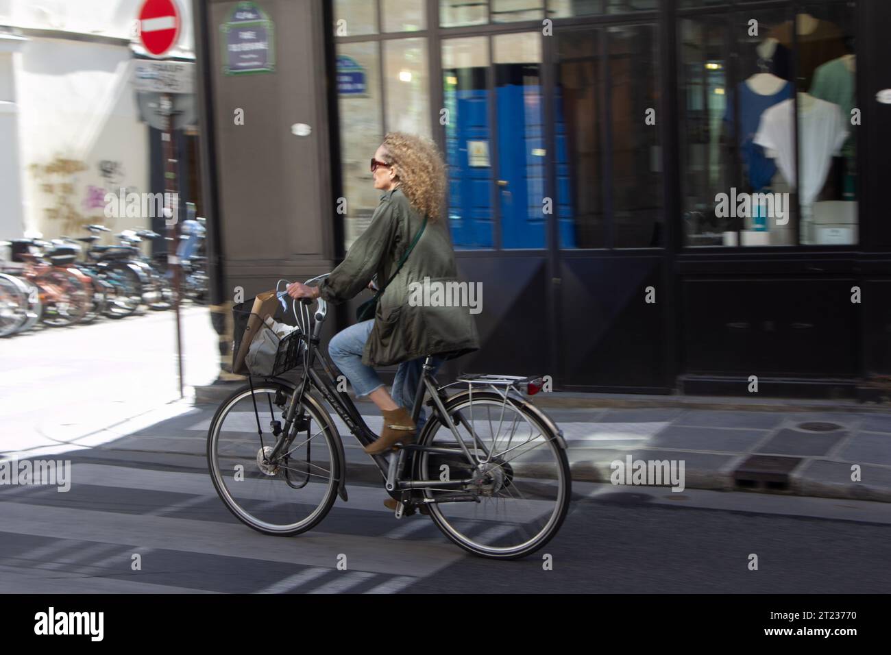 Una donna vestita con capi intelligenti corre lungo una strada nel centro di Parigi, in Francia. Foto Stock