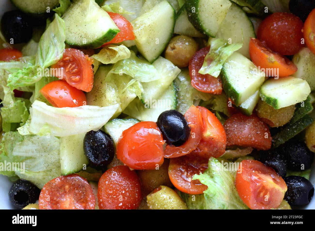 Avvicinati all'insalata mediterranea con lattuga, cetriolo, pomodori ciliegini e olive Foto Stock