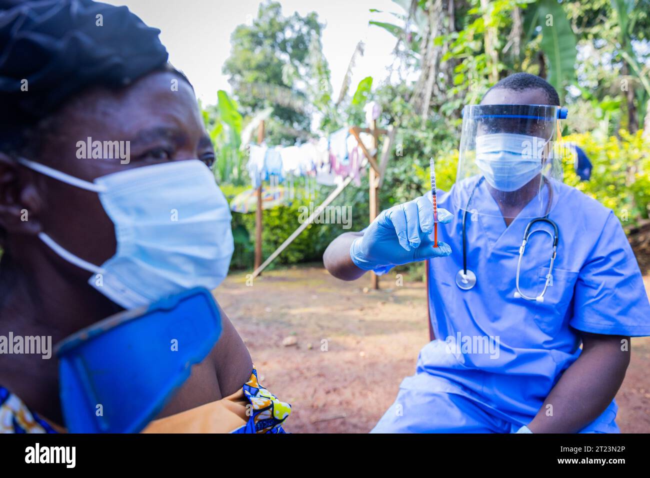La donna africana anziana scopre la spalla ed è pronta a ricevere l'iniezione da un medico. Foto Stock