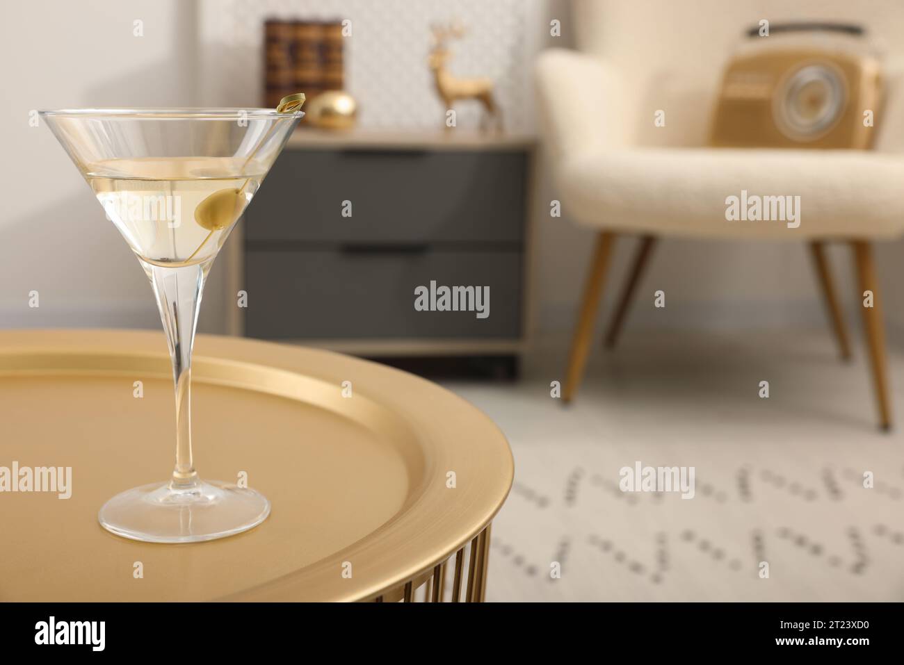 Cocktail Martini con olive sul tavolo in camera, spazio per testo. Rilassati a casa Foto Stock