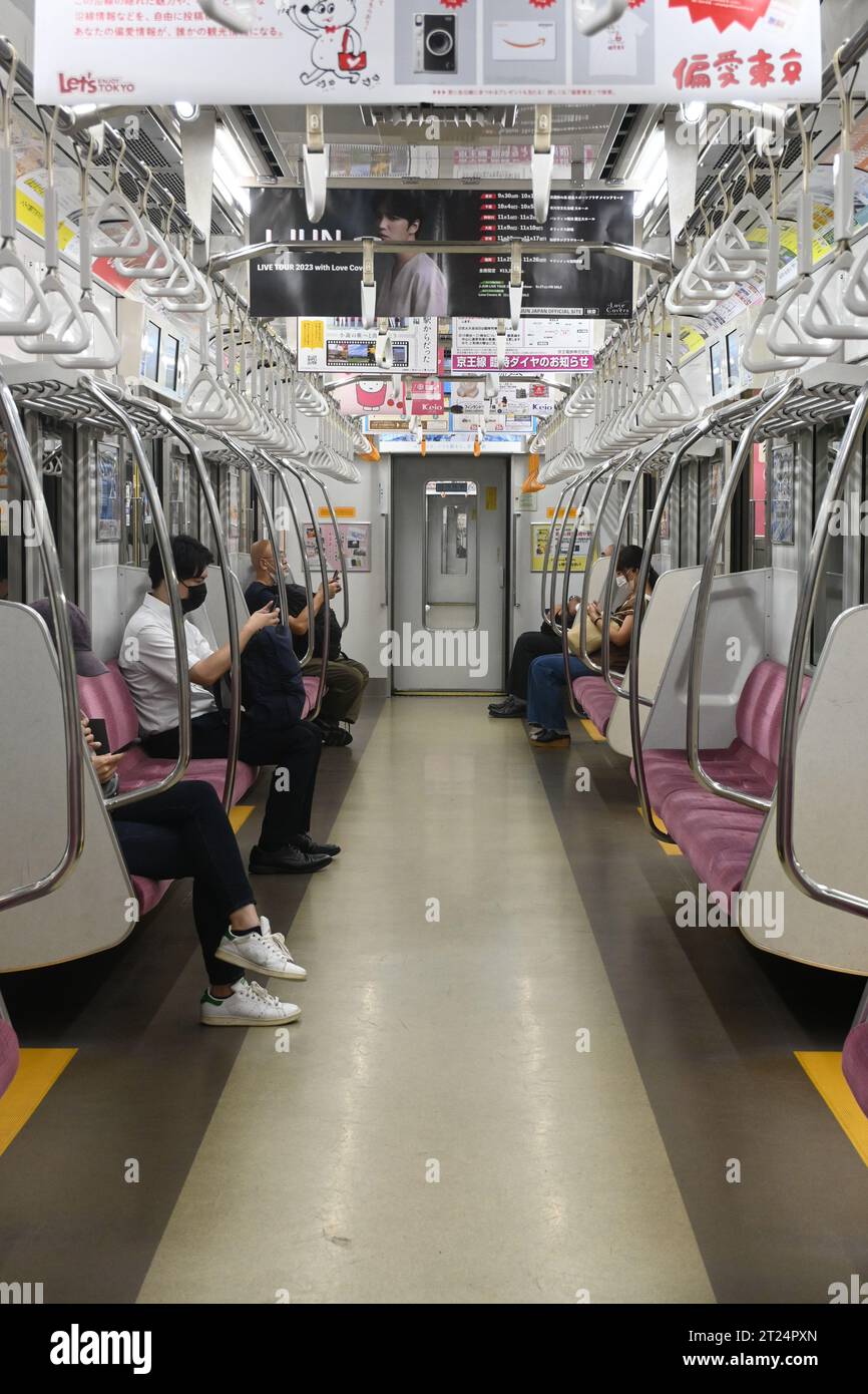 Un giro in metropolitana a Tokyo, prendendo un treno della linea Odeo. Tutti i passeggeri stanno guardando i loro telefoni. Foto Stock