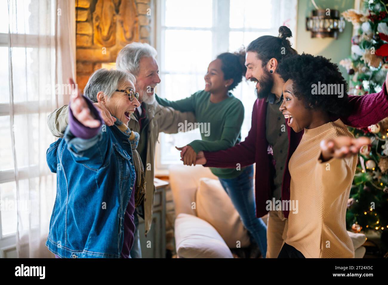 Eccitato saluto multietnico dei nonni il giorno di Natale. Famiglia felice multi-generazionale Foto Stock