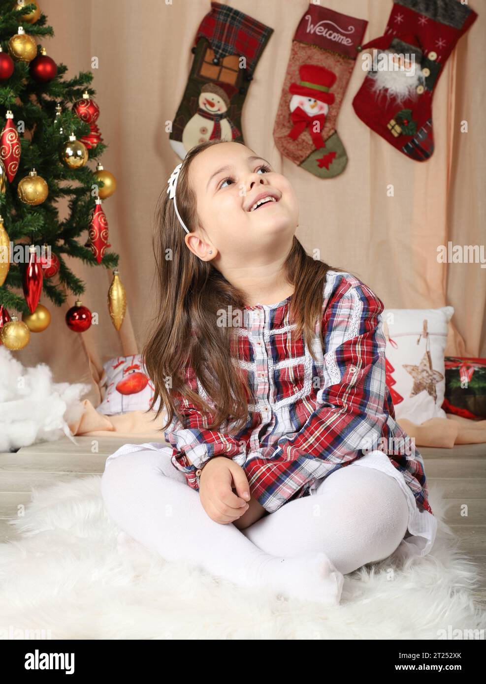 Bella bambina di fronte all'albero di natale Foto Stock