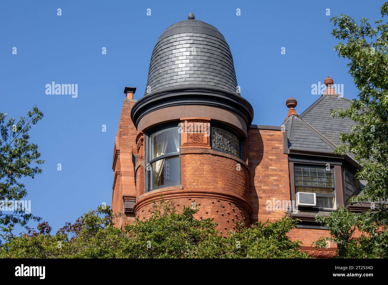 Un tradizionale edificio in mattoni con una torre decorata in ghisa che adorna la parte superiore di New York City, USA. Foto Stock