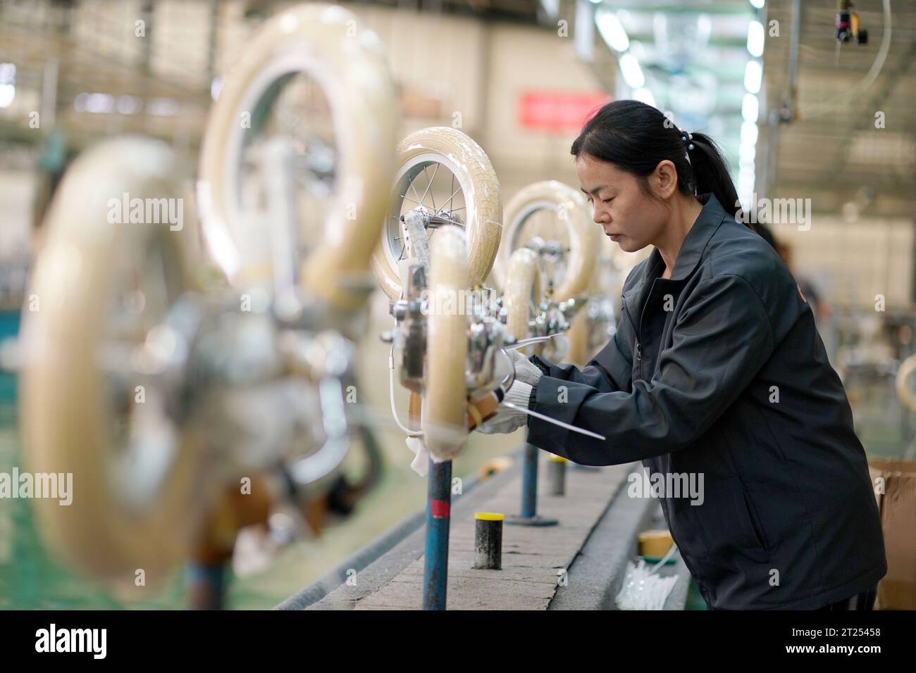 (231017) -- XINGTAI, 17 ottobre 2023 (Xinhua) -- Un operaio assembla una bicicletta per bambini in una società manifatturiera nella contea di Pingxiang, nella provincia di Hebei nella Cina settentrionale, 16 ottobre 2023. Pingxiang, soprannominata la "città delle ruote per bambini", negli ultimi anni ha compiuto grandi sforzi per potenziare il suo business di biciclette per bambini. I prodotti qui venduti sono stati venduti in oltre 60 paesi e regioni, tra cui Russia, Vietnam, Kenya e Sri Lanka. Il valore delle biciclette per bambini esportate direttamente dai produttori della contea è stato di 364 milioni di yuan (circa 49,76 milioni di dollari USA) nei primi sette mesi di questo YE Foto Stock