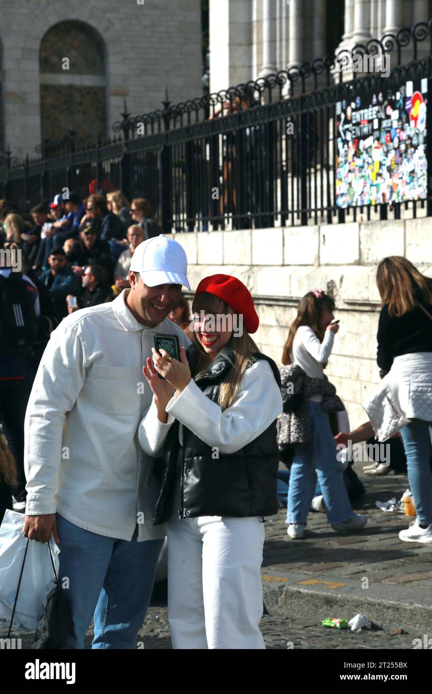 Una coppia amichevole che reagisce al loro selfie, alla Cattedrale del Sacro cuore durante il Montmartre Wine Festival a Parigi Foto Stock