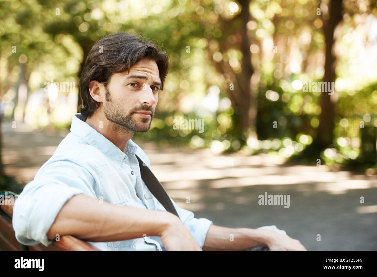Rilassatevi, pensate o fate una persona al parco su una panchina d'estate, per una vacanza all'aria aperta o per una pausa in giardino. Salute mentale, Italia o uomo calmo in natura Foto Stock