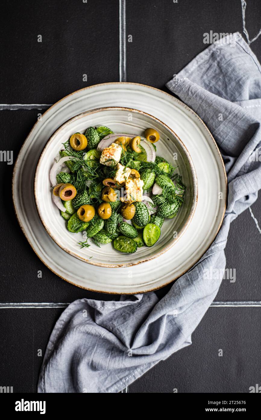 Vista dall'alto di una ciotola di cucamelon, olive e insalata di formaggio feta Foto Stock