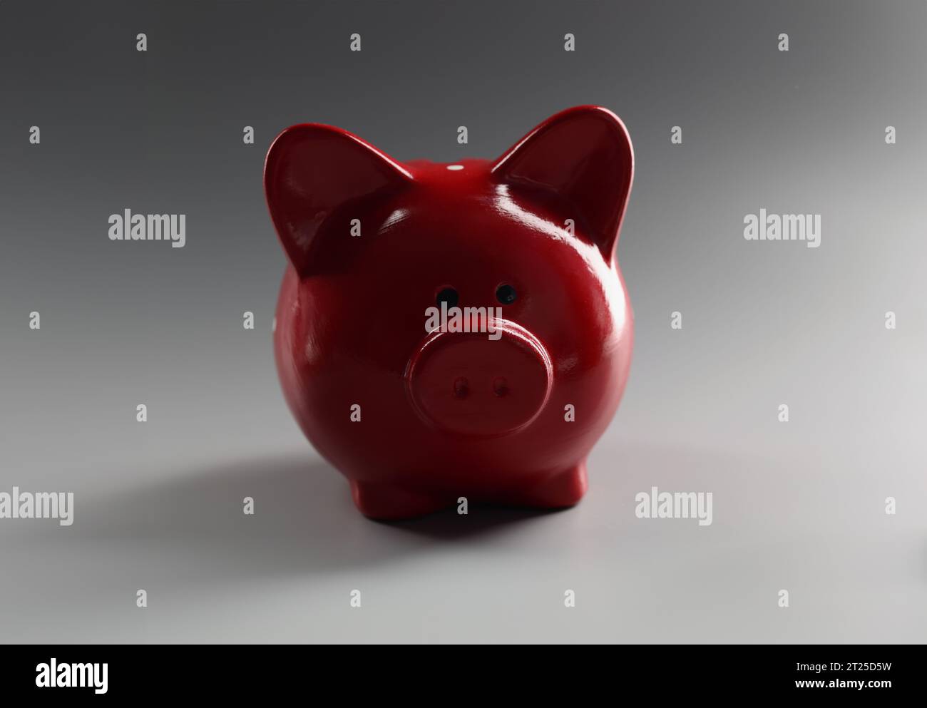 Contenitore rosso piggybank sulla superficie grigia, cosa per risparmiare denaro, animale in ceramica Foto Stock