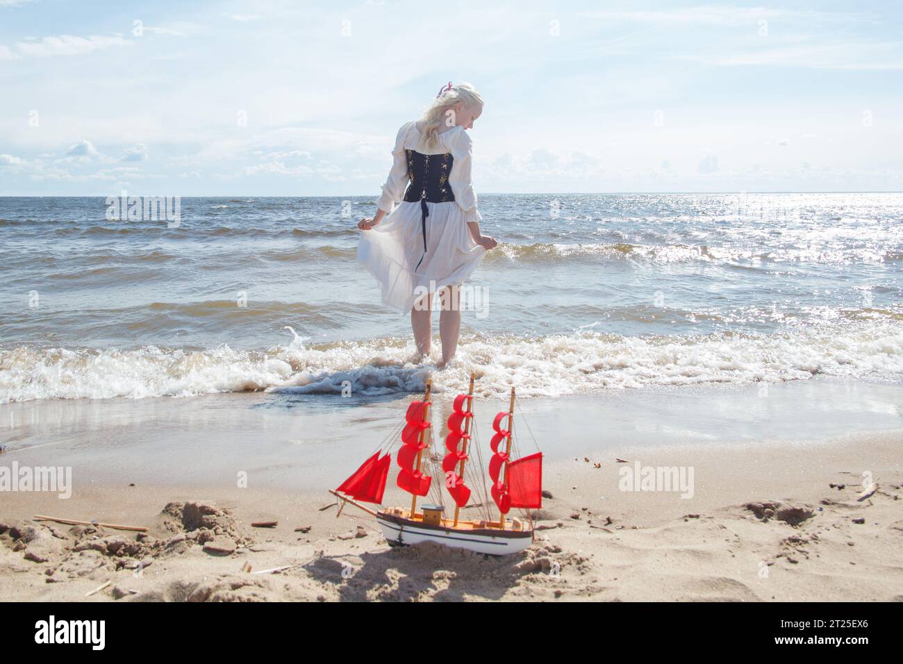 Bella donna con abito in stile retrò sulla spiaggia di mare Foto Stock