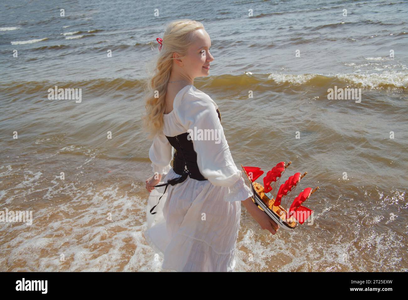 Bella giovane donna con i capelli biondi sul mare, ritratto all'aperto Foto Stock