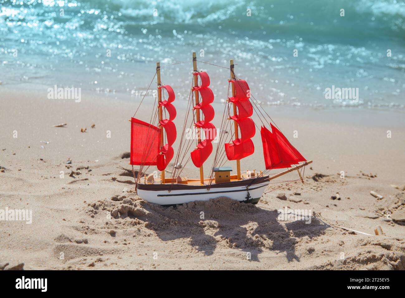 Naviga con vele rosse sullo sfondo della spiaggia. Concetto di viaggio, vacanza e crociera Foto Stock