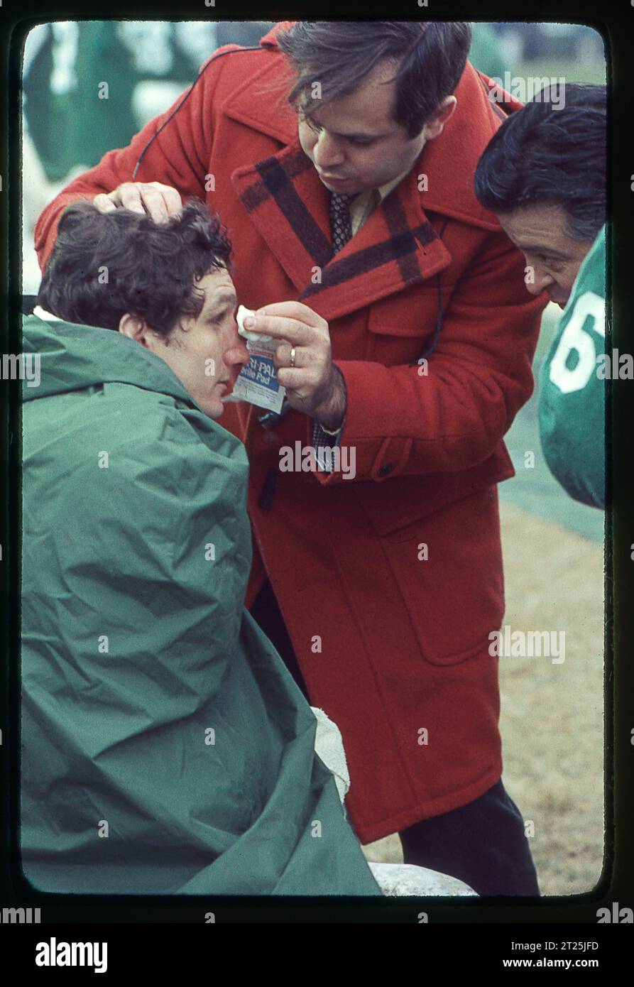 New York Jets ortopedico e medico di squadra Dr. Robert Grossman controlla la salute di un giocatore. Ai margini di una partita di football del 1978 allo Shea Stadium di New York. Grossman faceva parte dello staff dell'Institute of Sports Medicine and Athletic Trauma. L'atleta è John Roman, il lineman dei Jets. Foto Stock