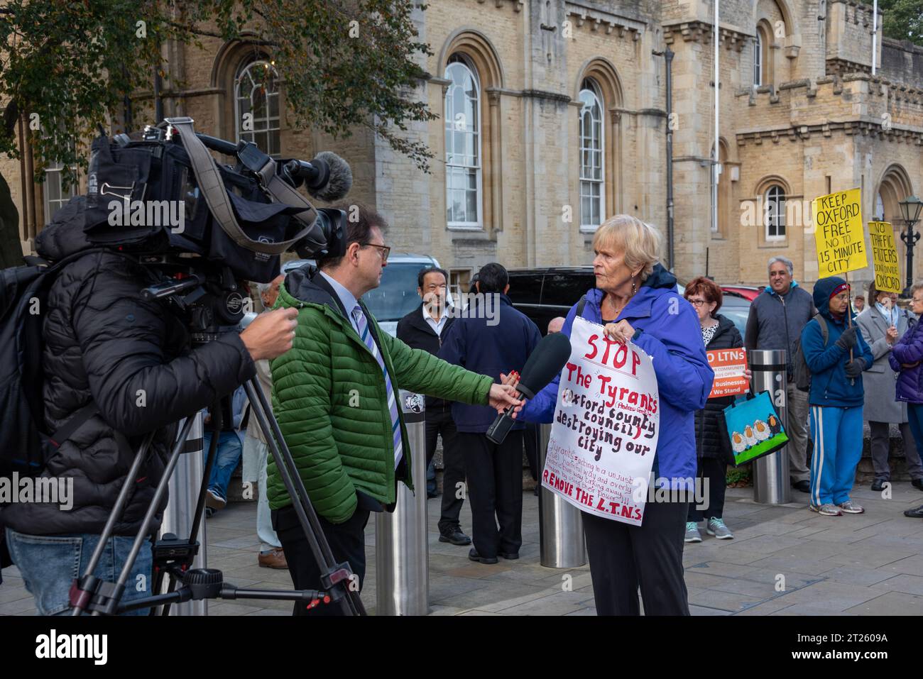 Oxford, Regno Unito, 17 ottobre 2023. Una manifestazione fuori County Hall, Oxford, contro i quartieri a basso traffico (LTNs) che sono stati molto controversi dalla loro introduzione in città negli ultimi due anni. Il Consiglio della Contea stava votando per renderli permanenti e un piccolo ma vocale gruppo di residenti locali e uomini d'affari si riunirono per far sentire la loro voce, guidato da Clinton Pugh, padre dell'attrice Florence Pugh, che possiede diversi ristoranti locali ed è stato attivo nella sua opposizione al regime del traffico. Qui un protestore è intervistato dal notiziario locale di ITV. Credito: Marti Foto Stock