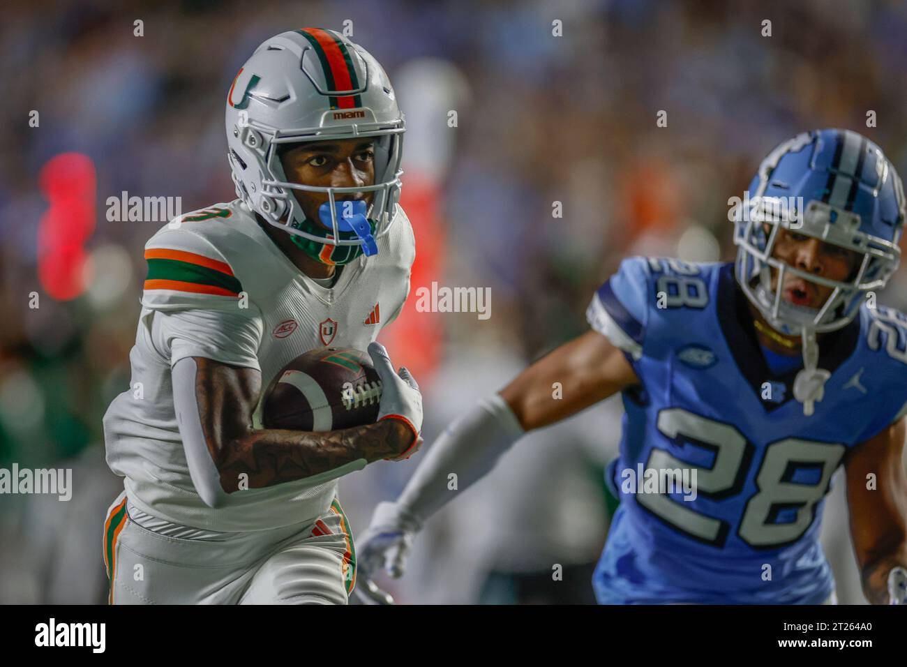 Chapel Hill, NC USA: Il wide receiver dei Miami Hurricanes Jacolby George (3) corre con la palla dopo aver fatto un ricevimento mentre è strettamente coperto da North caro Foto Stock