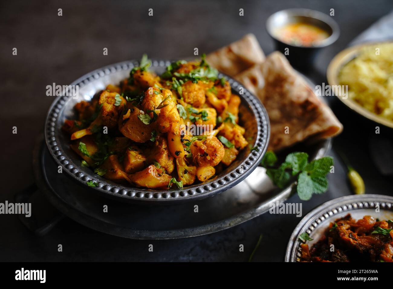 Aloo Gobi fatto in casa - curry vegetariano indiano fatto con patate e cavolfiore servito con riso e roti Foto Stock