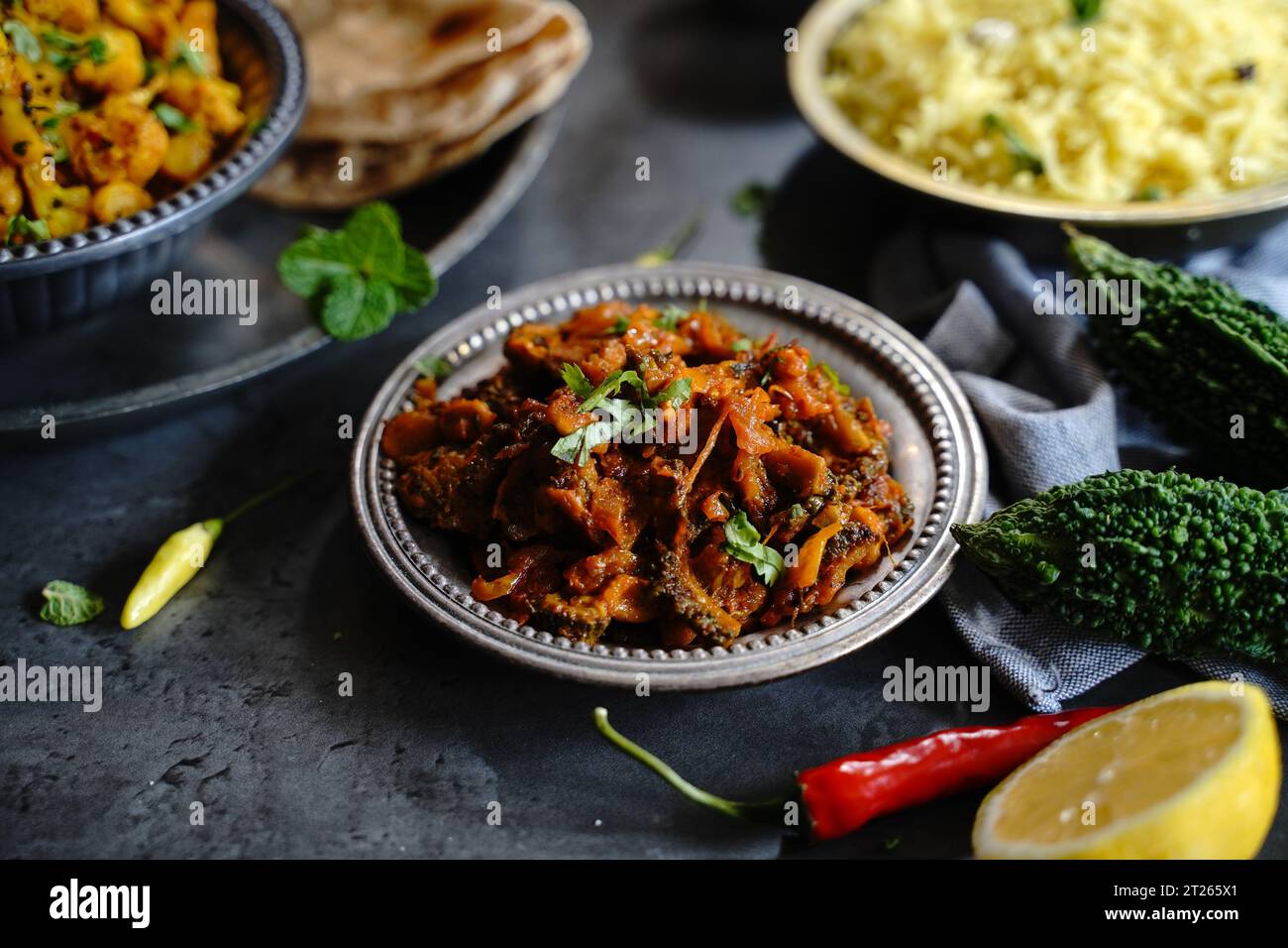 Curry di zucca amara - karela subji servito con riso e roti, fuoco selettivo Foto Stock