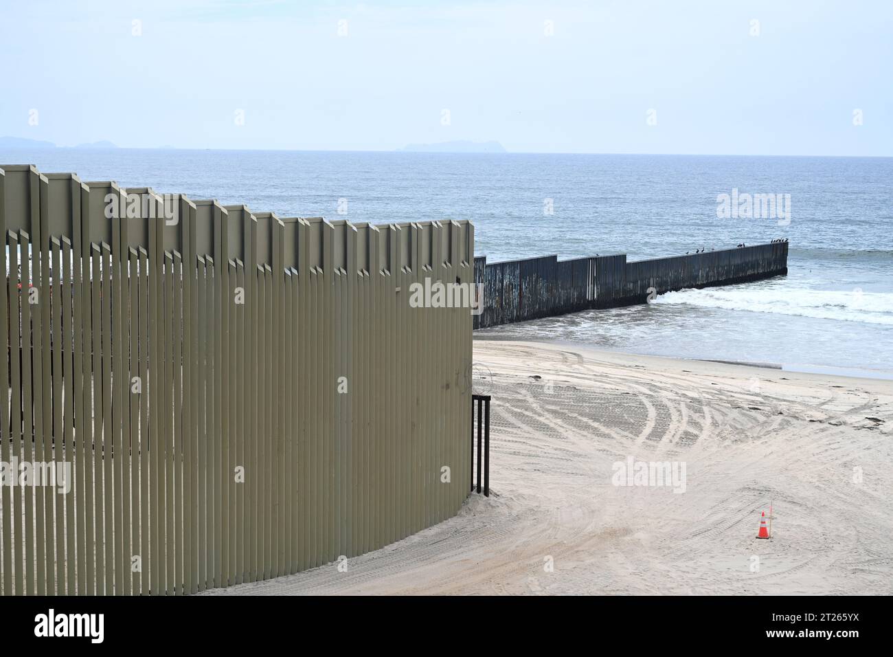 Una recinzione sul confine tra Stati Uniti e Messico, dove incontra l'Oceano Pacifico al confine con la spiaggia di Field State Park Foto Stock