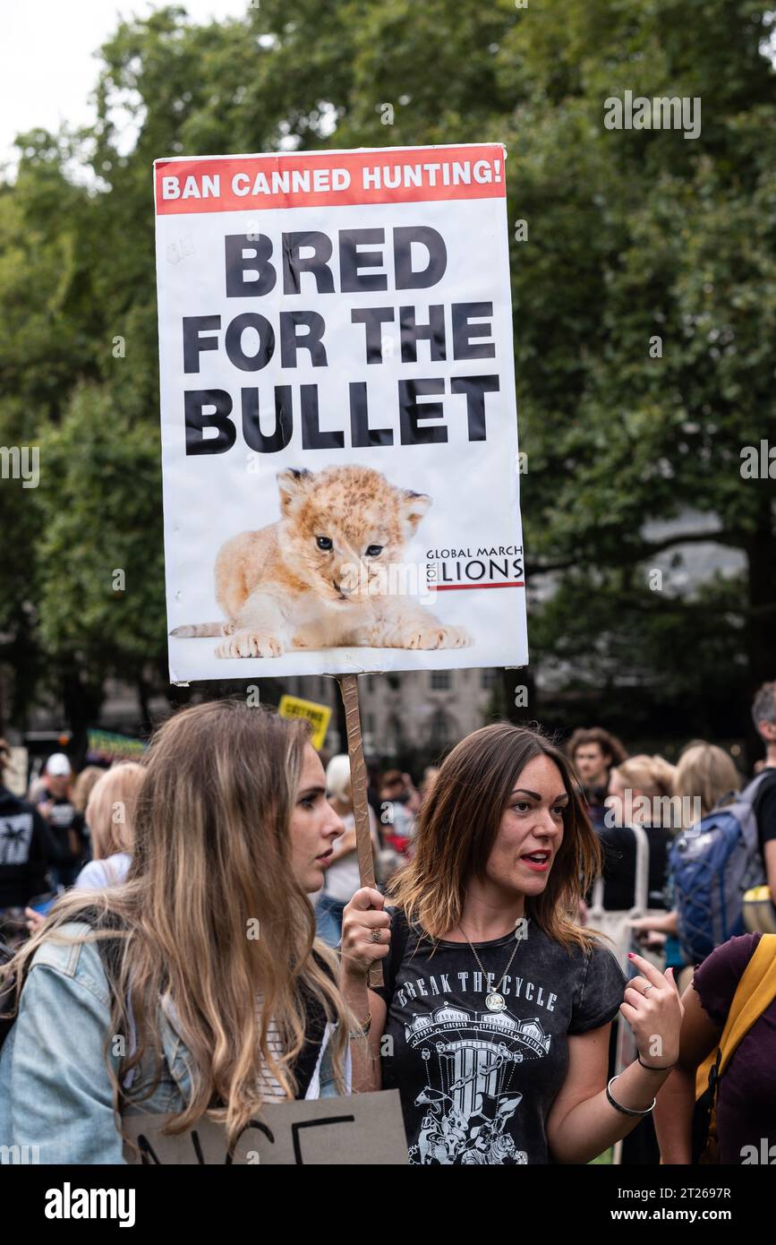 La marcia ufficiale dei diritti degli animali si svolge con i manifestanti al di fuori delle camere del Parlamento. Cartello che protesta contro la caccia ai trofei Foto Stock