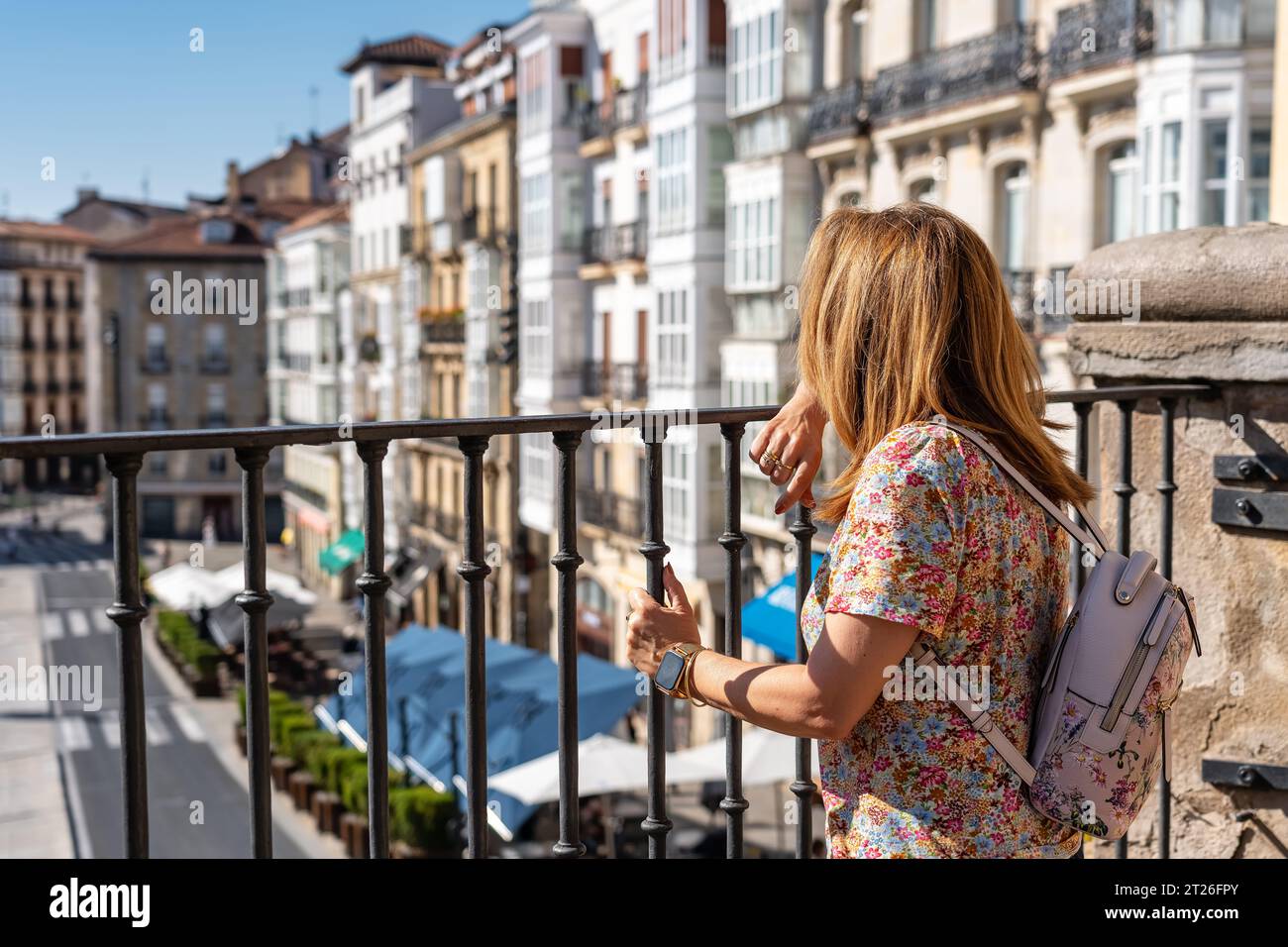 Donna turistica con le spalle ai pittoreschi edifici della città monumentale di Vitoria, Spagna. Foto Stock