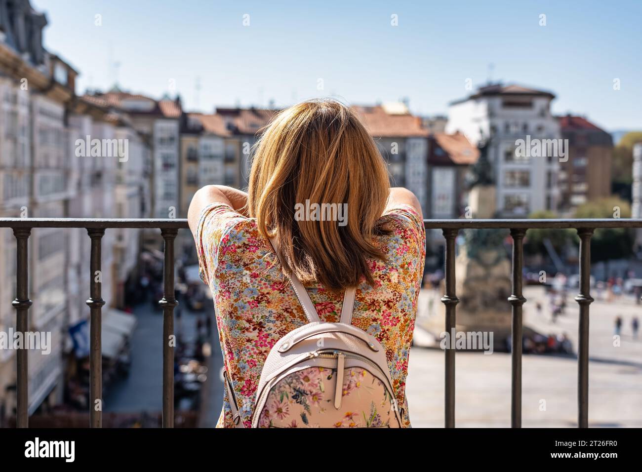 Donna turistica con le spalle ai pittoreschi edifici della città monumentale di Vitoria, Spagna. Foto Stock