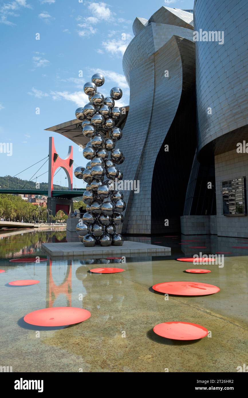 Laghetto all'esterno del museo d'arte Guggenheim con "l'arco rosso" (dell'artista Daniel Buren) sullo sfondo del ponte la Salve. Bilbao, Spagna. Foto Stock