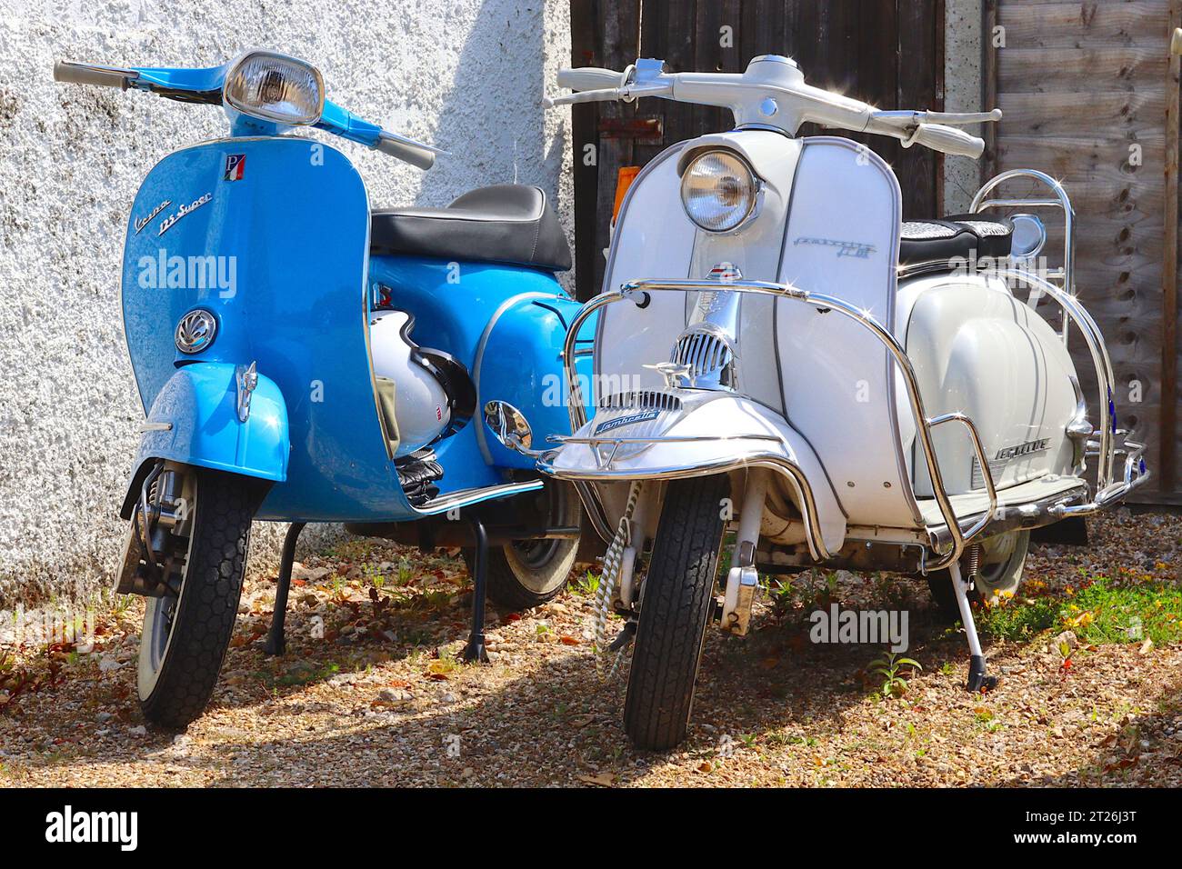 Vespa Blue Piaggio 125 Super e Lambretta Li125 serie 1 in avorio parcheggiati. La Lambretta è dotata di copertura per corno cromato e parafango. Foto Stock