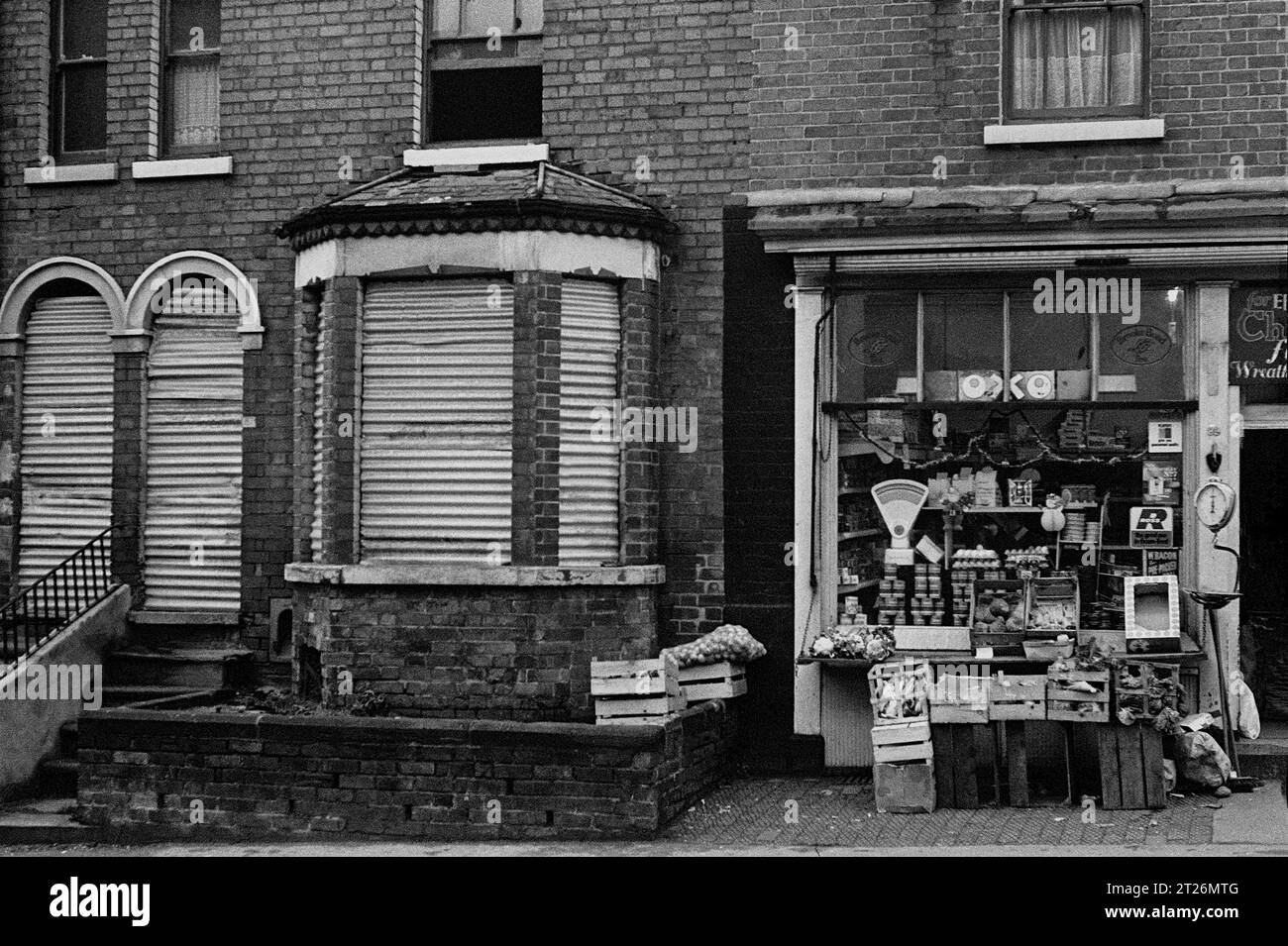 Negozio all'angolo che vende frutta e verdura accanto a una casa affondata durante lo slum e la demolizione di St Ann's, Nottingham.1969-1972 Foto Stock
