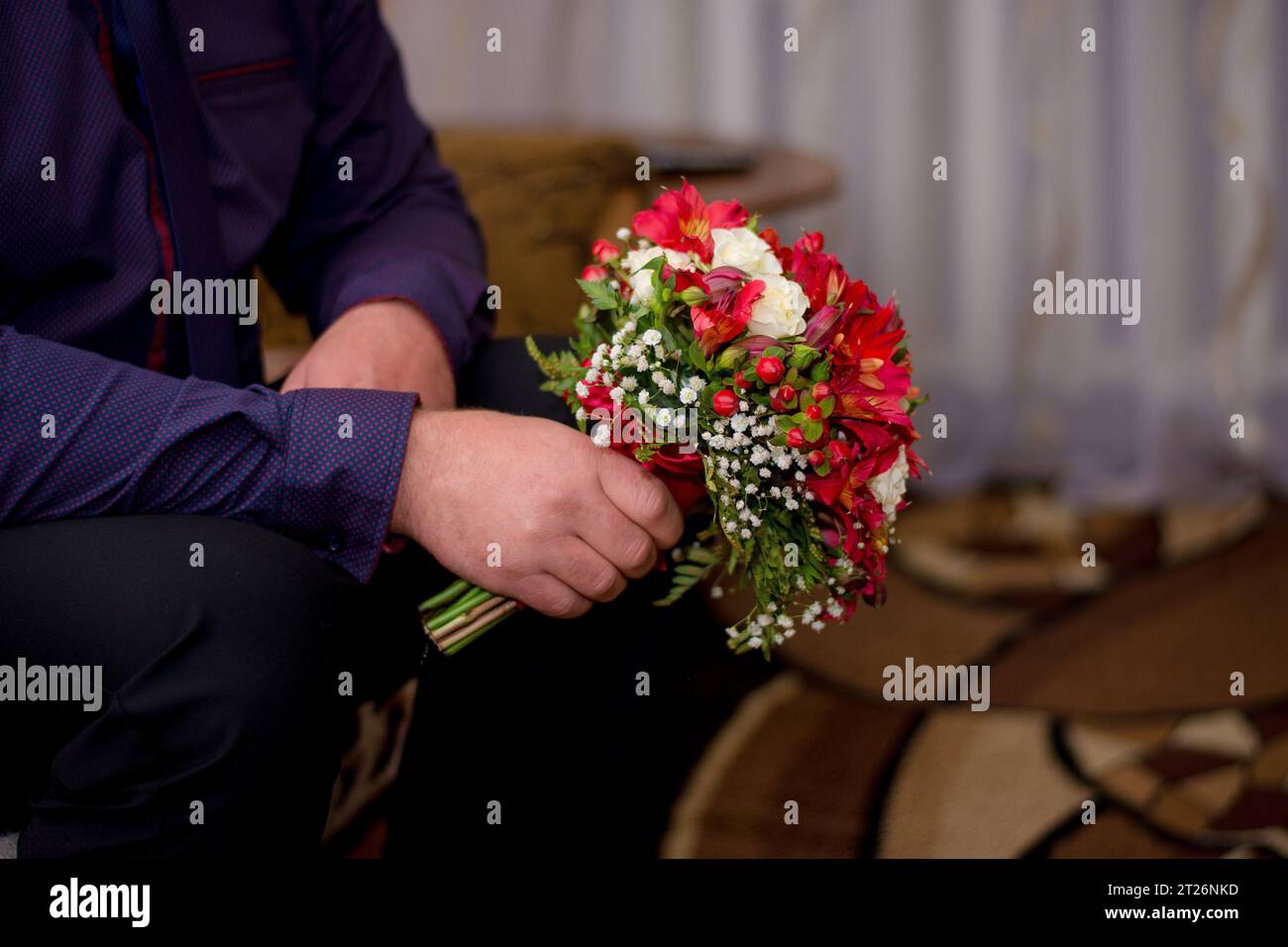 nelle mani di un uomo un bouquet di bellissimi fiori. Foto Stock