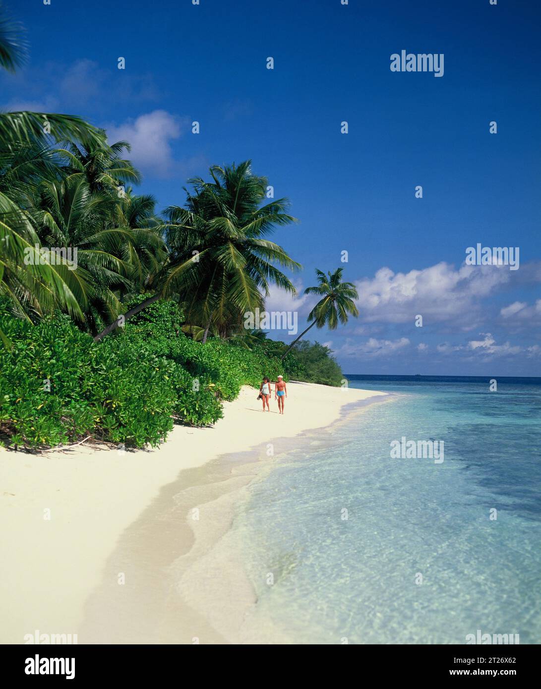Maldive. Coppia che cammina sulla spiaggia tropicale di sabbia bianca. Foto Stock