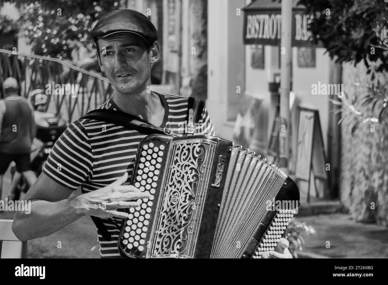 Happy Street Performer che suona la fisarmonica nel centro storico di Antibes, in Francia Foto Stock