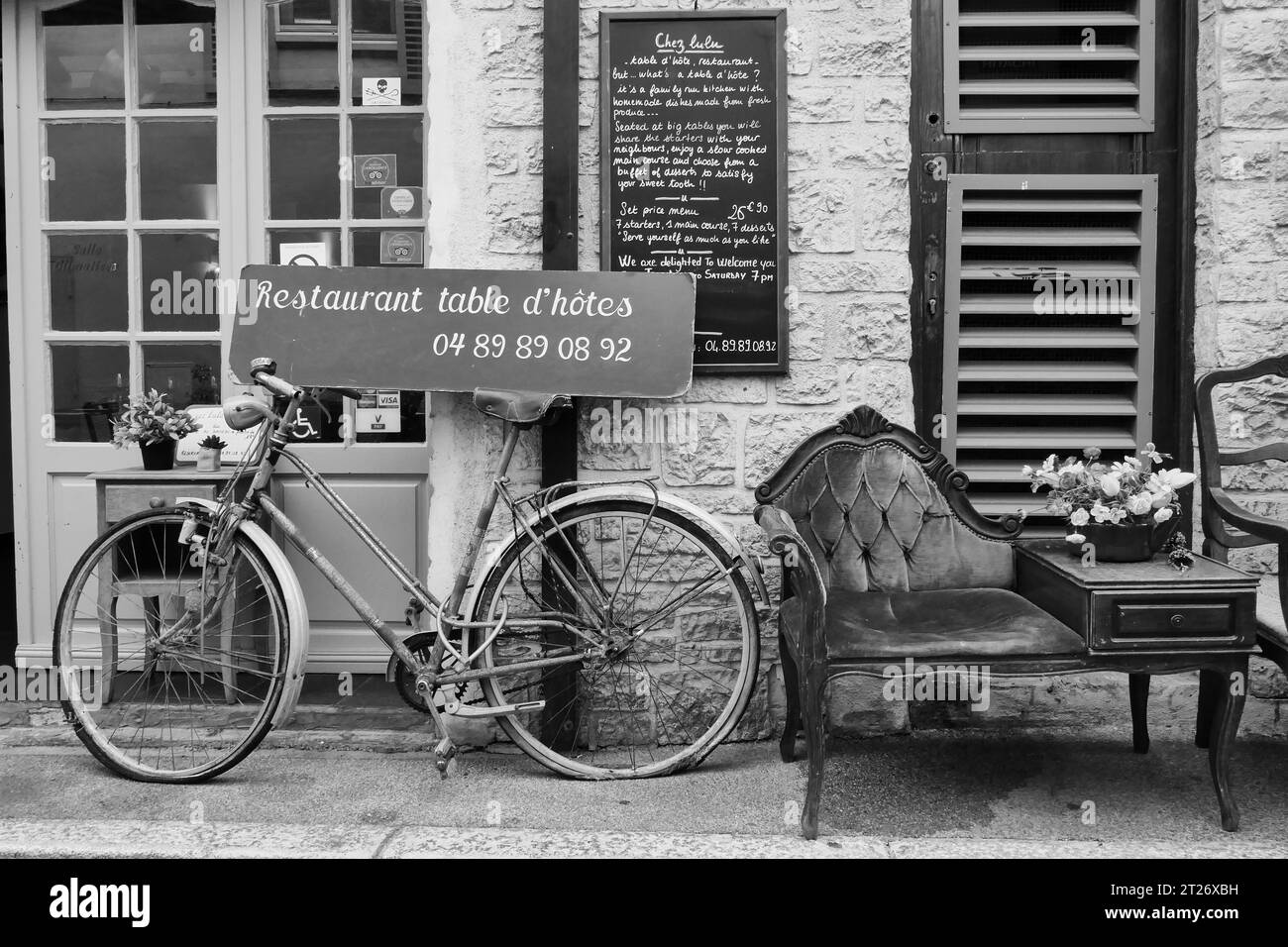 Bicicletta e sedia vintage all'esterno di un affascinante ingresso alla caffetteria francese ad Antibes, Francia Foto Stock