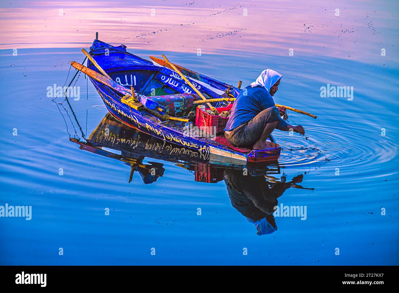 Lone Fisherman con la cattura giornaliera di un piccolo sciabordo sul Nilo a Luxor Foto Stock