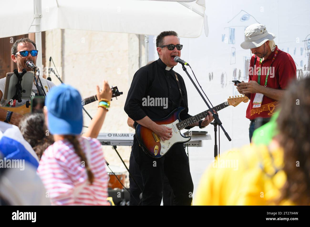 Una band, tra cui un prete cattolico, che tiene un concerto durante le Giornate mondiali della gioventù 2023 a Lisbona, Portogallo. Il concerto si è svolto vicino alla chiesa di St Roch. Foto Stock