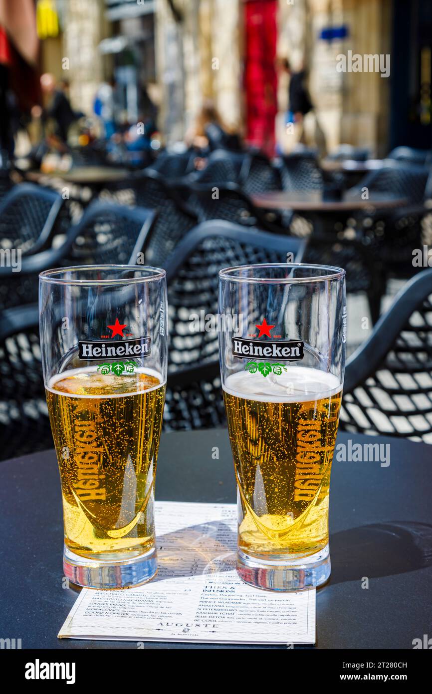 Due bicchieri da birra con marchio Heineken da mezzo pieno su un tavolo in un bar caffetteria a Bordeaux, una città portuale sul fiume Garonna nel sud-ovest della Francia Foto Stock