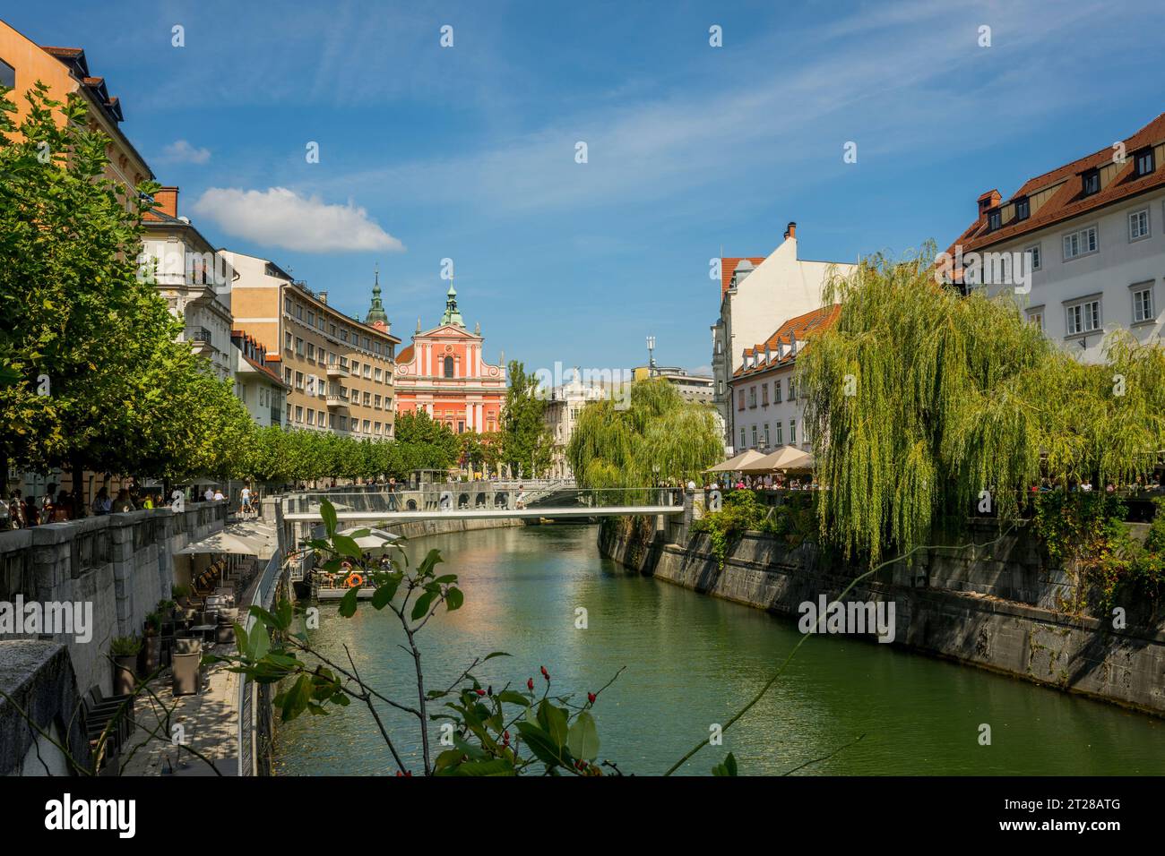 Il fiume Ljubljanica nella vecchia Lubiana, Slovenia, con sullo sfondo la Chiesa francescana dell'Annunciazione. Foto Stock