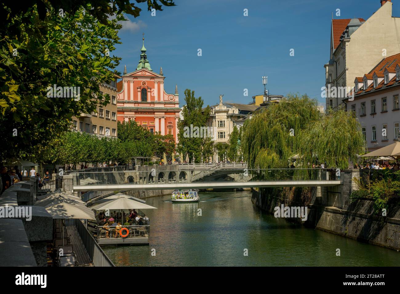 Il fiume Ljubljanica nella vecchia Lubiana, Slovenia, con sullo sfondo la Chiesa francescana dell'Annunciazione. Foto Stock