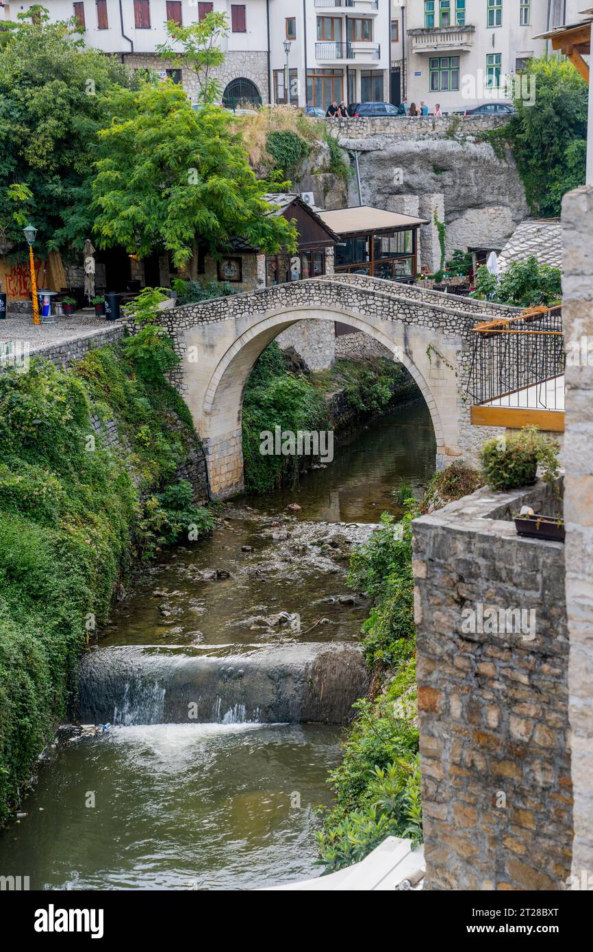 Vista del Kriva Cuprija (Ponte Crooked) sul fiume Radobolja, un piccolo e vecchio ponte in pietra a Mostar, Bosnia ed Erzegovina, costruito nel 1558 da Foto Stock