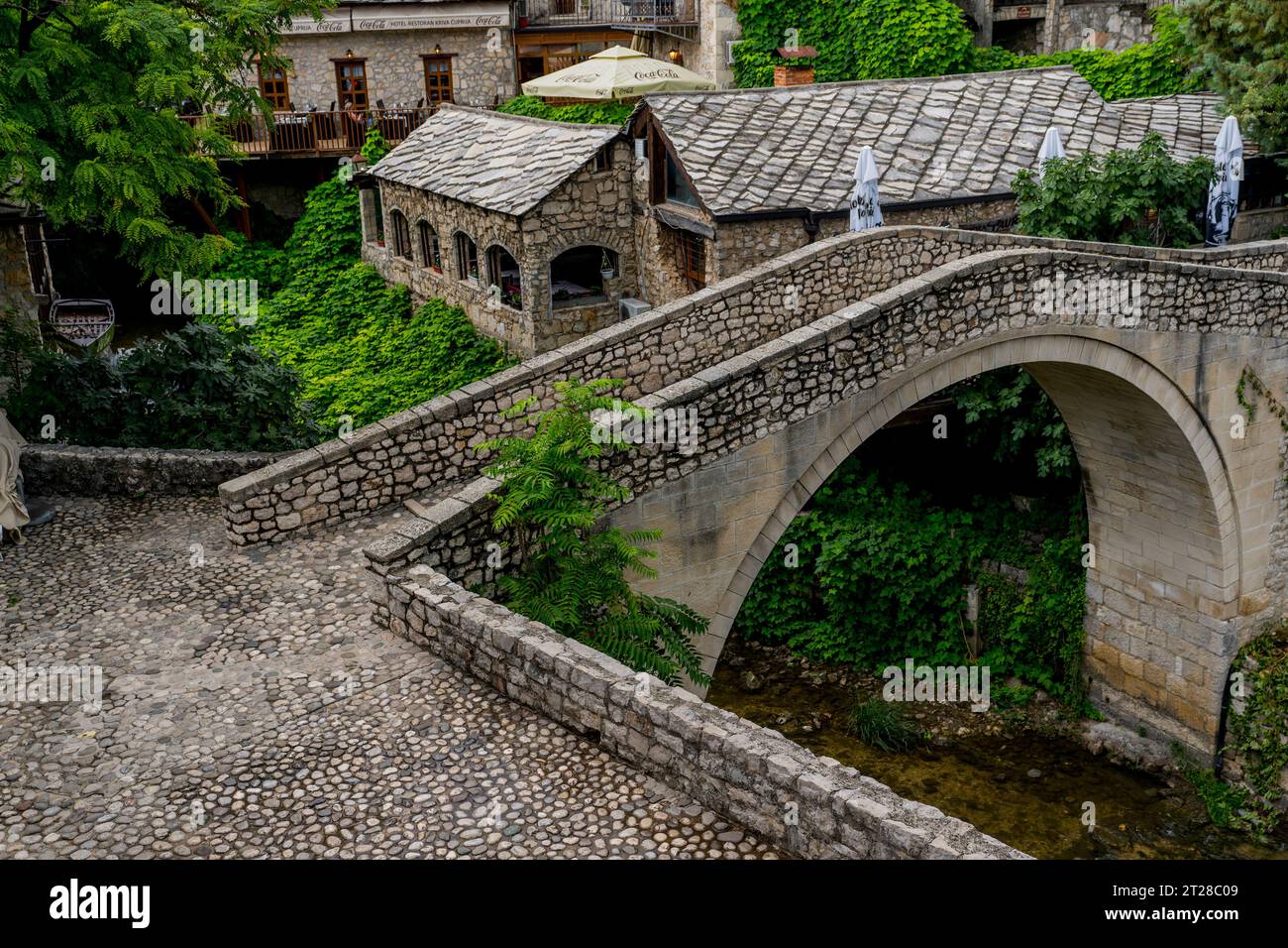Il Kriva Cuprija (Ponte Crooked) sul fiume Radobolja, un piccolo e vecchio ponte in pietra a Mostar, Bosnia ed Erzegovina, costruito nel 1558 da otto Foto Stock