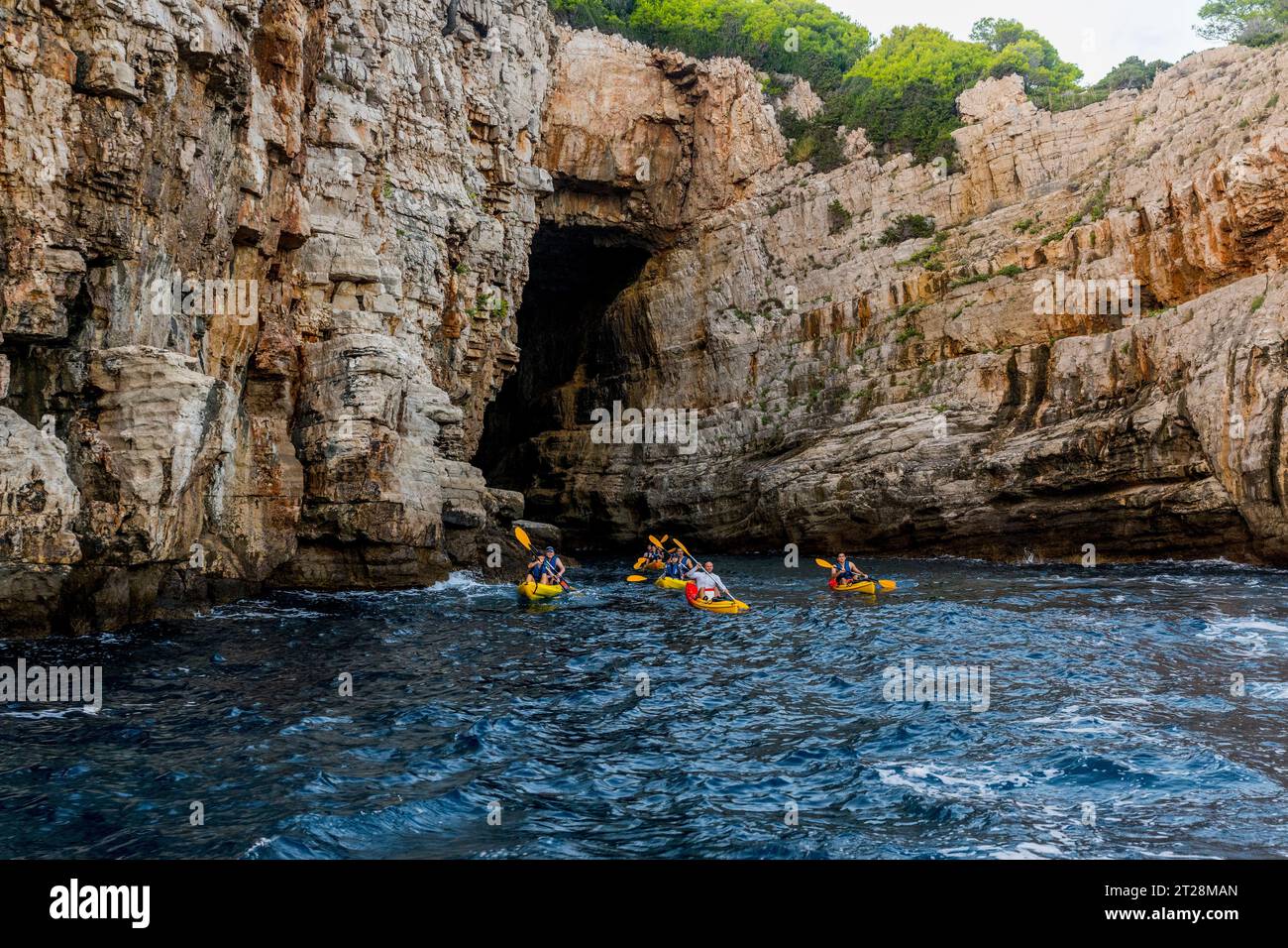 Kayak che esplorano le grotte dell'isola di Lokrum di fronte alla città vecchia di Dubrovnik, nella Croazia meridionale. Foto Stock