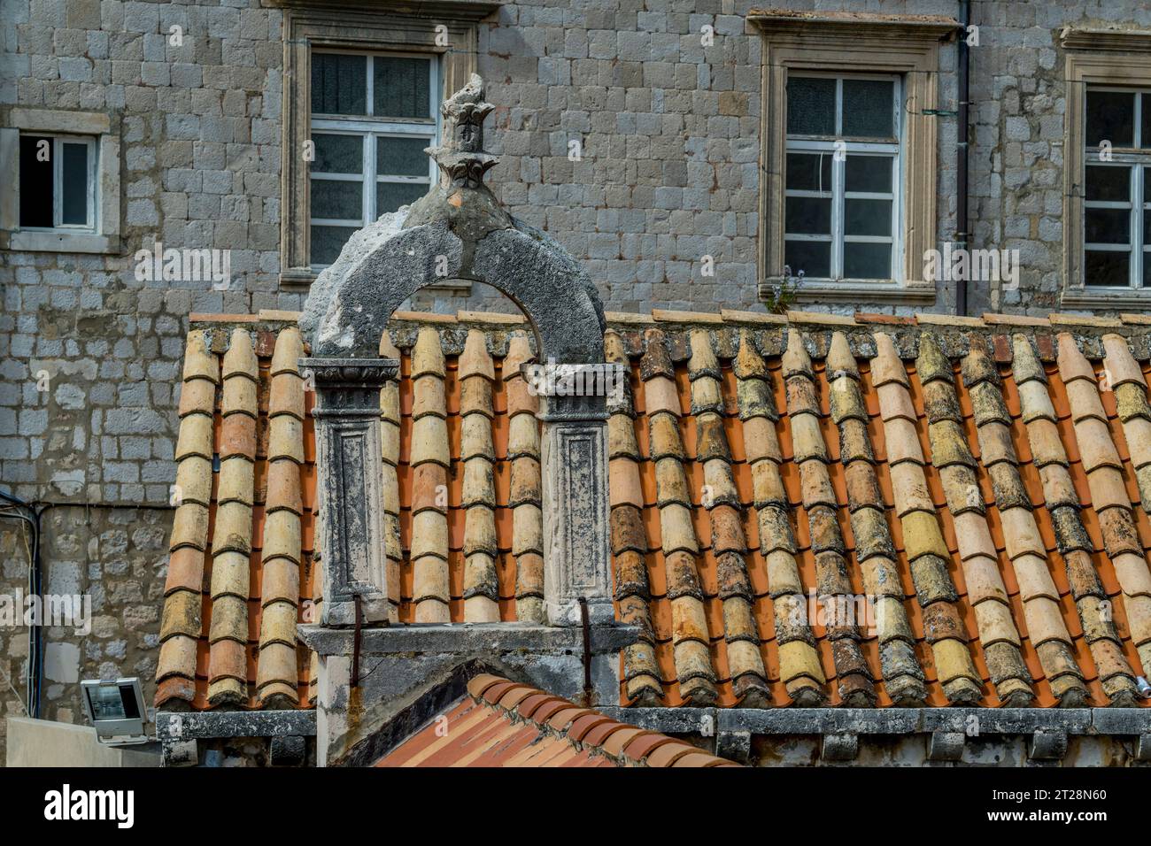 Vista dalla passeggiata delle mura della città dei tetti piastrellati e di un vecchio campanile nella città vecchia di Dubrovnik, nel sud della Croazia. Foto Stock