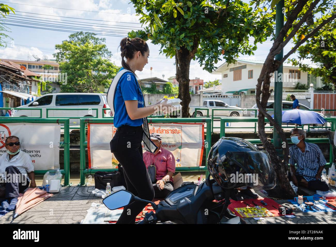 Bangkok, Thailandia. 14 ottobre 2023. Miss Thailand World 2023, Tharina Botes è visto portare scatole gratuite di cibo da dare ai cittadini thailandesi a basso reddito con la fondazione Bangkok Community Help, presso la comunità Trok Sake, a Bangkok. Miss Thailand World 2023, Tharina Botes, patrimonio misto thailandese-sudafricano, si unì come volontario a una dispensa di pasti gratuiti per senzatetto e persone a basso reddito, organizzata dalla Bangkok Community Help Foundation, a Bangkok, Thailandia. (Foto di Nathalie Jamois/SOPA Images/Sipa USA) credito: SIPA USA/Alamy Live News Foto Stock